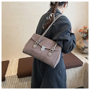 Detail of retro matte brown underarm bag with silver buckle and suede texture