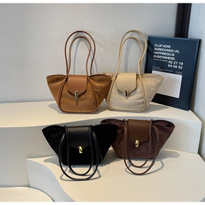 Detail of four colorful tote bags in suede and leather with sleek cylindrical handles
