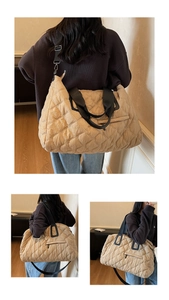 Detailed back view of a beige quilted tote bag with black straps and zip pocket details