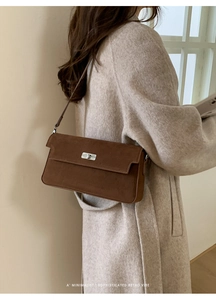 Close-up of brown suede rectangular shoulder bag with silver metal swivel lock