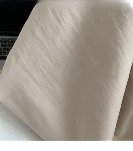 Detailed macro view of beige canvas fabric texture with subtle wrinkled weave patterns