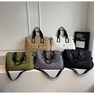 Five quilted large-capacity travel tote bags in various colors on display steps
