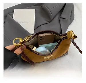 Detail of spacious interior of brown quilted crossbody bag with golden clasp hardware