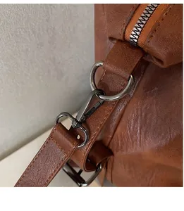 Close-up of brown lychee grain leather texture with gunmetal hardware and zipper