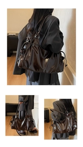 Detail of dark brown patent leather texture and drawstring closure on shoulder bag
