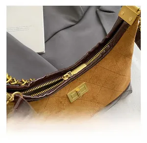 Close-up of golden rotating lock and quilted suede texture on a vintage dumpling bag