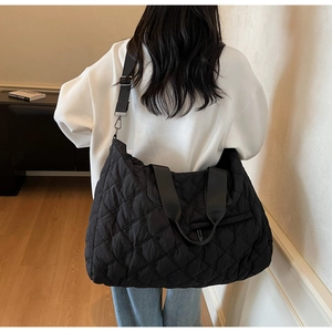 Detailed back view of a black quilted puffer shoulder bag showing large size and texture