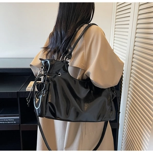 Détail du sac cabas noir brillant avec cordon de serrage et longues bandoulières
