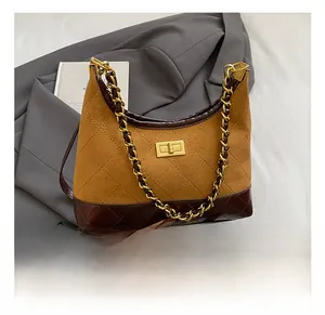 Detail of quilted suede crossbody bag with gold chain and metal twist lock closure