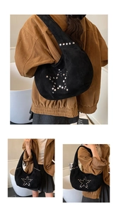 Detail of star-shaped silver rivet patterns on black suede hobo shoulder bag for women