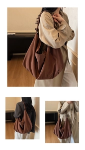 Detail of a brown canvas hobo bag with a knotted strap and decorative wooden bead ornament