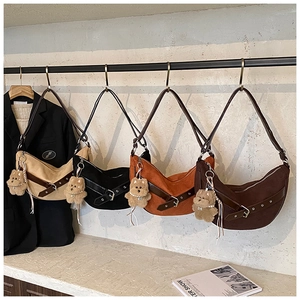 Detailed display of four leopard print crescent bags with plush bear charms and adjustable straps