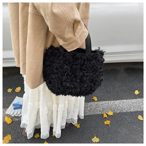 Outdoor street style view of a plush black bucket bag with soft faux fur texture
