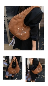 Detail of brown suede hobo bag with silver star rivets in an outdoor street setting