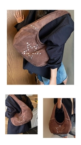 Detail of brown suede hobo bag with star-shaped silver metal rivet studs and handle