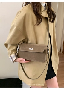 Detail of coffee brown suede crossbody bag showing silver twist lock and minimalist flap