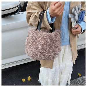 Detail of curly faux shearling bucket bag with black leather handle in street scene