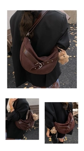 Brown suede crescent shoulder bag with leopard accent and plush dog charm detail