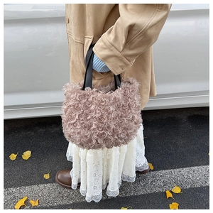 Detailed view of plush teddy fabric bucket bag in dusty pink with black straps