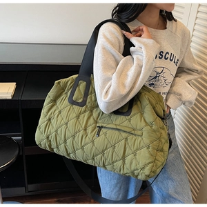 Close-up of olive green quilted tote bag featuring embroidery diamond lattice and zip pocket