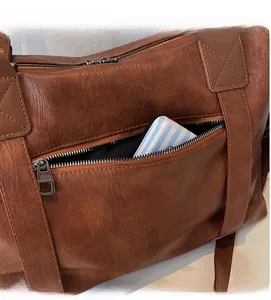 Detail view of large brown vintage leather travel bag featuring a durable zipper pocket