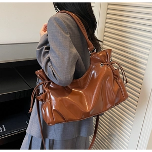 Vue détaillée du grand sac cabas marron brillant avec cordon de serrage et texture en cuir