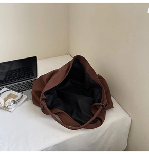 Deep interior view of large brown shoulder bag with magnetic snap and bead detail
