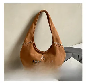 Detail showing brown suede hobo bag with silver star-patterned rivets in home setting