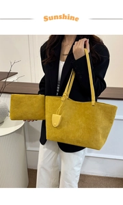 Detail of yellow matte leather tote bag and matching pouch with tassel on a table
