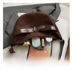 Detailopname van de ruime suède tas met ruimte voor een tablet en cosmetica