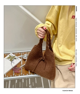 Detailed close-up of brown knit handbag with bow decoration and textured material