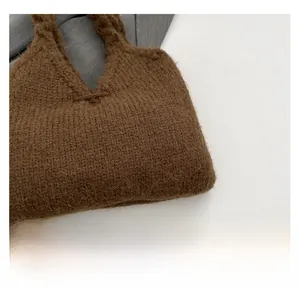 Close-up of premium dark brown knit handbag showing soft wool texture and ribbon bow detail