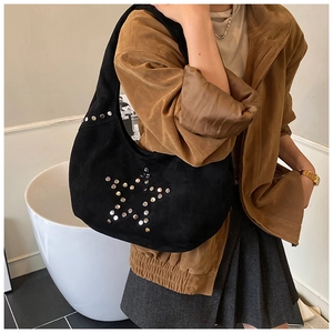Detail of black suede tote bag featuring silver star stud rivets on a half-moon silhouette
