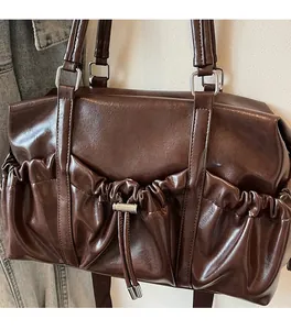 Detail of dark brown vintage bowling bag with shiny leather texture and drawstring pocket