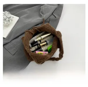 Top view of spacious knit tote interior showing phone, cosmetics, and accessories