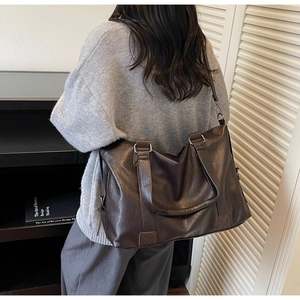 Detail view of the vintage brown pillow bag showing the durable shoulder strap and leather texture