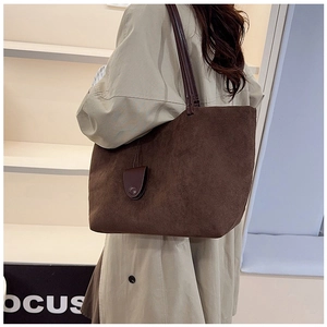 Detailed view of dark brown suede tote bag with matte texture and decorative pendant