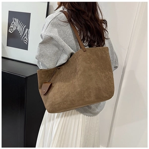 Close-up of brown suede tote bag with slim straps and a matching hanging accessory pouch