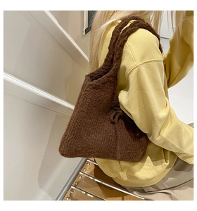 Detail of a brown chunky knit shoulder bag with soft wool texture for autumn styling