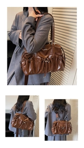 Detail view of brown pleated leather shoulder bag with detachable wide strap on a model