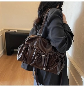 Detailed close-up of dark brown vintage tote bag with elegant ruching and shiny PU leather