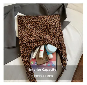 Detailed interior of leopard print suede bucket bag showing tablet and cosmetics capacity