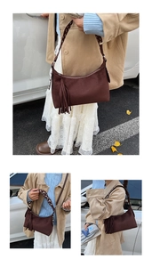 Close-up of vintage brown suede shoulder bag featuring long tassels and studded strap detail