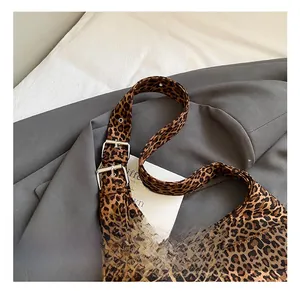 Detail showing the adjustable shoulder strap with silver metal buckle on leopard print bag