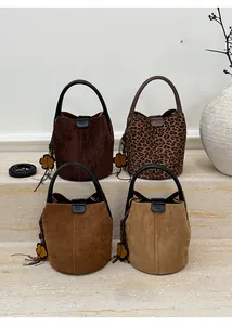 Close-up of vintage bucket bags in leopard print and suede finish with floral charms