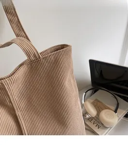 Close-up of khaki corduroy tote bag texture with large capacity and soft fabric detail