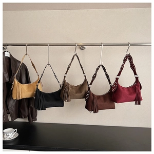 Detail of bohemian fringe bags in five colors with metal studs on shoulder straps