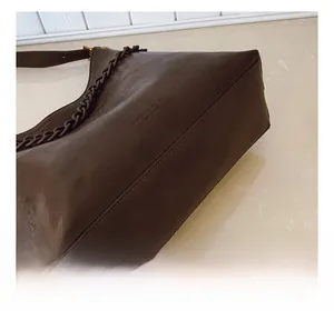 Detailed view of precision stitching and leather texture on a brown shoulder bag