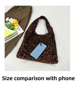 Leopard print tote bag size comparison with a smartphone on flat lay background