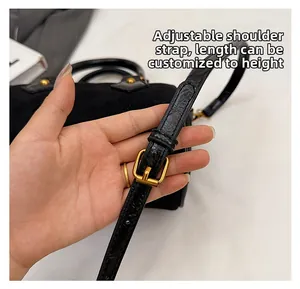 Detalle de correa ajustable con hebilla dorada en bolso Boston de ante negro mate